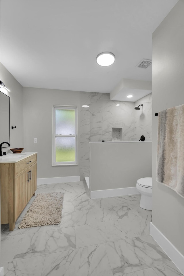 full bathroom with baseboards, marble look tiles, a walk in shower, toilet, and vanity