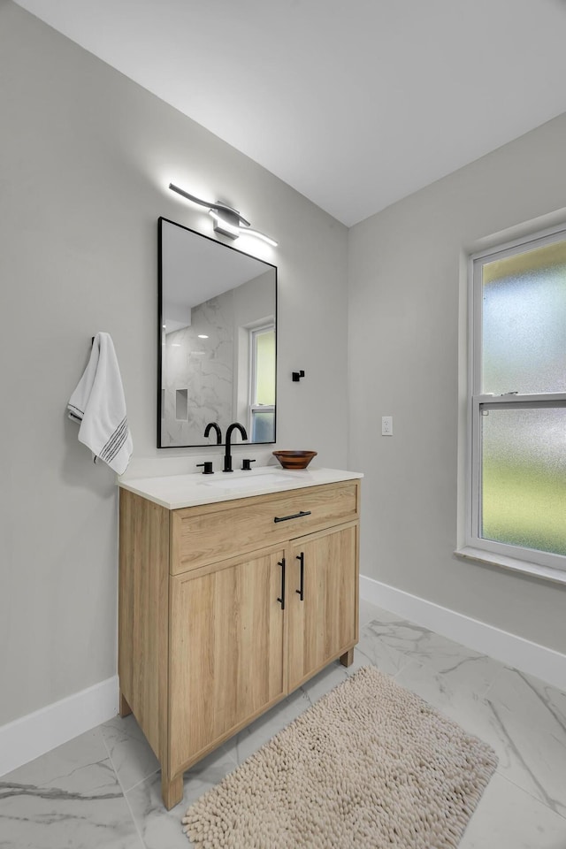 bathroom featuring marble finish floors, baseboards, and vanity