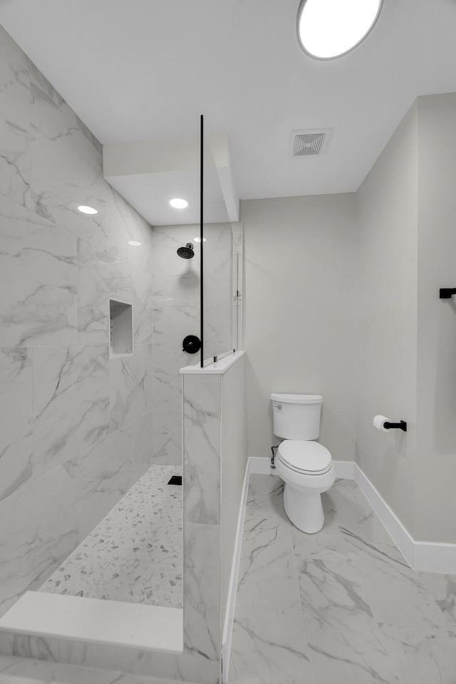 bathroom featuring marble finish floors, baseboards, toilet, and a marble finish shower