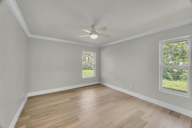 spare room with a ceiling fan, ornamental molding, light wood-style flooring, and baseboards