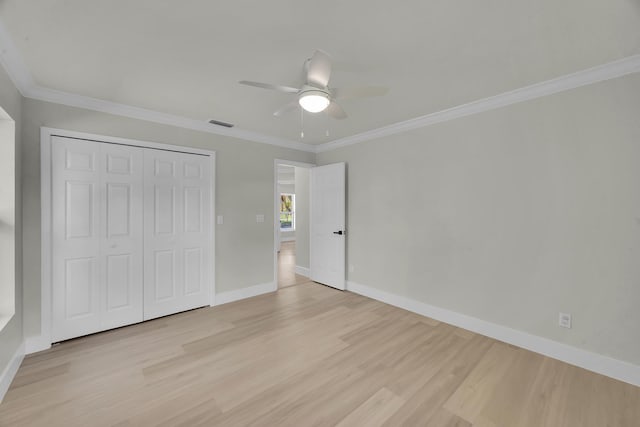 unfurnished bedroom featuring light wood-style floors, a closet, baseboards, ornamental molding, and a ceiling fan