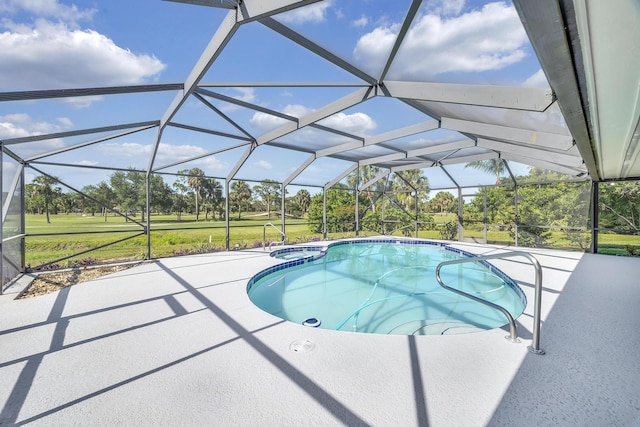 view of swimming pool with a patio, a pool with connected hot tub, glass enclosure, and a lawn