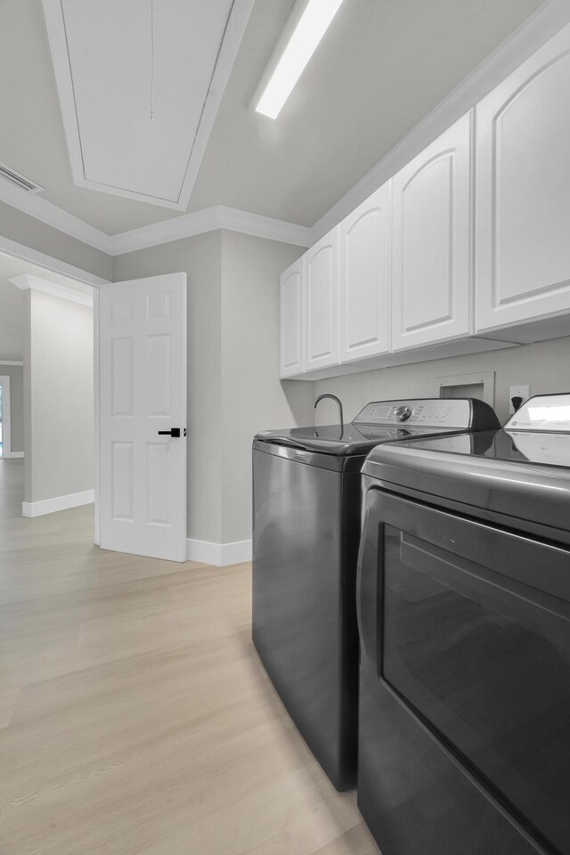 4365 SW Bimini Cir S, Palm City, FL 34990 - laundry room featuring cabinet space, independent washer and dryer, attic access, baseboards, and light wood-type flooring