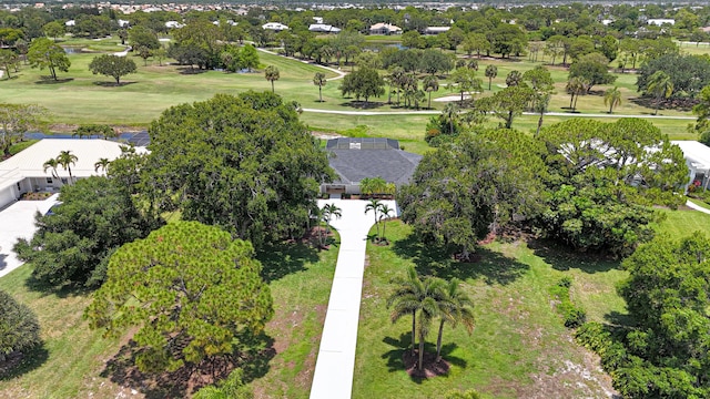 drone / aerial view of a golf course and a tree filled landscape