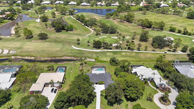 view of property location featuring a nearby body of water, a golf course, and nearby suburban area