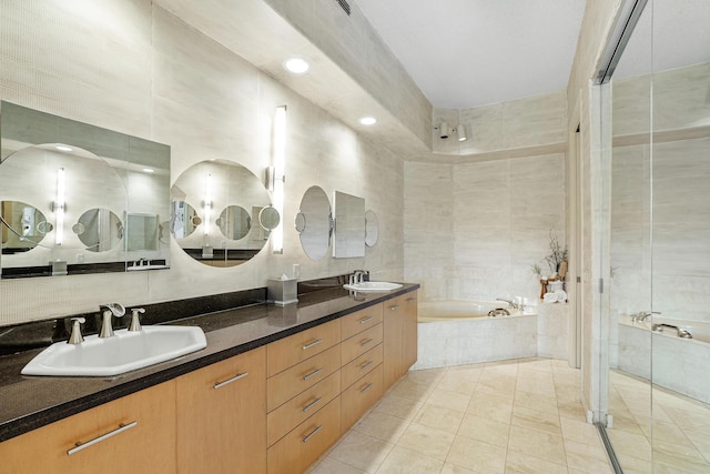 17652 Ashbourne D Way Unit D, Boca Raton, FL 33496 - bathroom featuring tile walls, a garden tub, a shower stall, tile patterned floors, and double vanity
