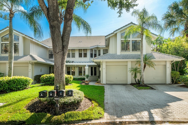 17652 Ashbourne D Way Unit D, Boca Raton, FL 33496 - view of front facade featuring a tile roof, a garage, decorative driveway, stucco siding, and a front yard