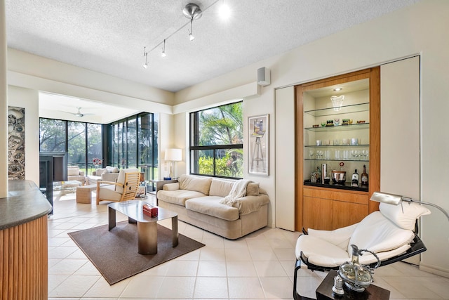 17652 Ashbourne D Way Unit D, Boca Raton, FL 33496 - living area featuring plenty of natural light, a textured ceiling, and light tile patterned floors