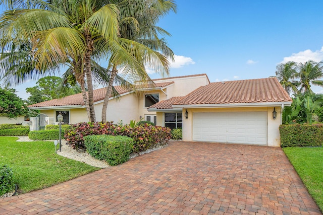 4877 Pineview Cir, Delray Beach, FL 33445 - view of front of property with stucco siding, decorative driveway, a garage, a front lawn, and a tiled roof