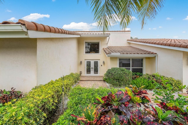 4877 Pineview Cir, Delray Beach, FL 33445 - property entrance featuring french doors, a tiled roof, and stucco siding