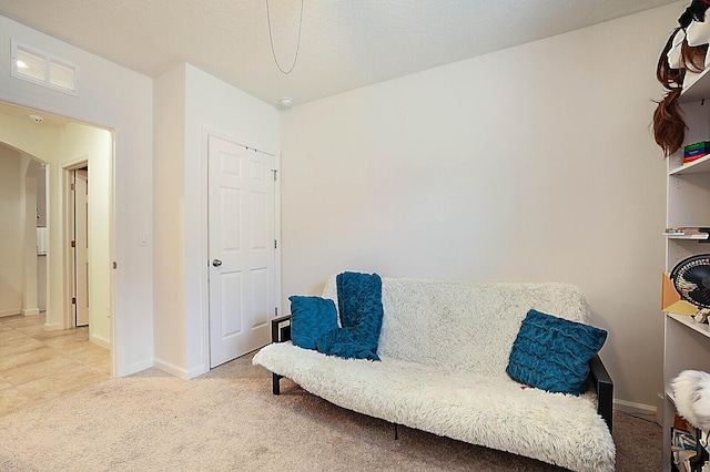 6241 NW Regent St, Port Saint Lucie, FL 34983 - living area with arched walkways, baseboards, and light colored carpet