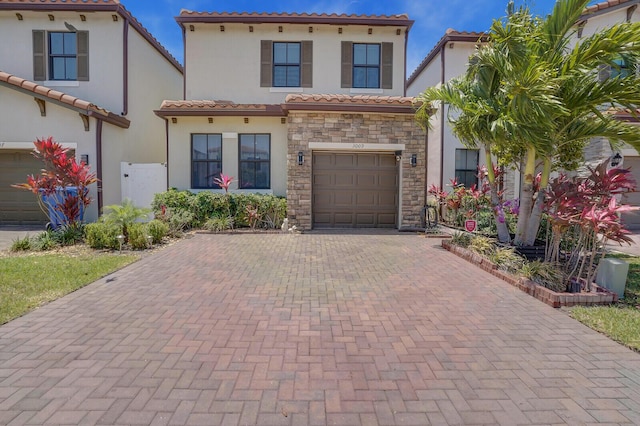3009 Hop Tree Way, Riviera Beach, FL 33410 - mediterranean / spanish-style house featuring a tile roof, decorative driveway, stucco siding, and stone siding
