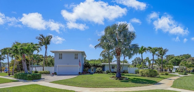 605 Flotilla Ln, North Palm Beach, FL 33408 - view of front of home with an attached garage, driveway, and stucco siding