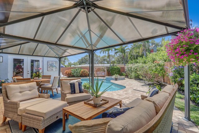 605 Flotilla Ln, North Palm Beach, FL 33408 - view of swimming pool featuring french doors, an outdoor living space, a fenced backyard, and a patio area