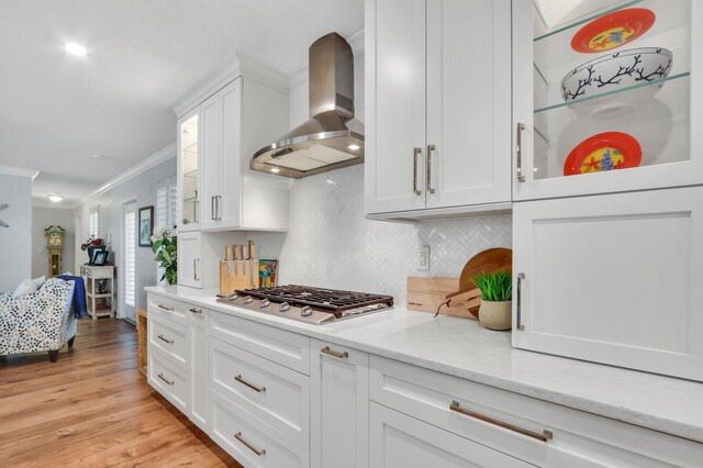 605 Flotilla Ln, North Palm Beach, FL 33408 - kitchen featuring wall chimney exhaust hood, stainless steel gas stovetop, ornamental molding, backsplash, and white cabinetry