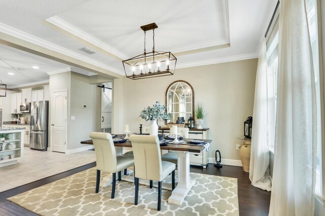 4052 SW Mccandless St, Port Saint Lucie, FL 34953 - dining space with healthy amount of natural light, wood finished floors, a barn door, ornamental molding, and recessed lighting