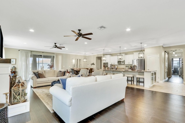 4052 SW Mccandless St, Port Saint Lucie, FL 34953 - living room with crown molding, healthy amount of natural light, a ceiling fan, recessed lighting, and dark wood-style flooring