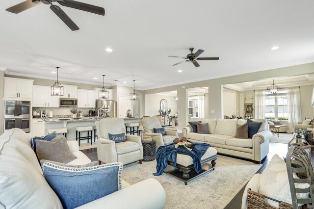 4052 SW Mccandless St, Port Saint Lucie, FL 34953 - living room featuring a ceiling fan, crown molding, recessed lighting, and a chandelier