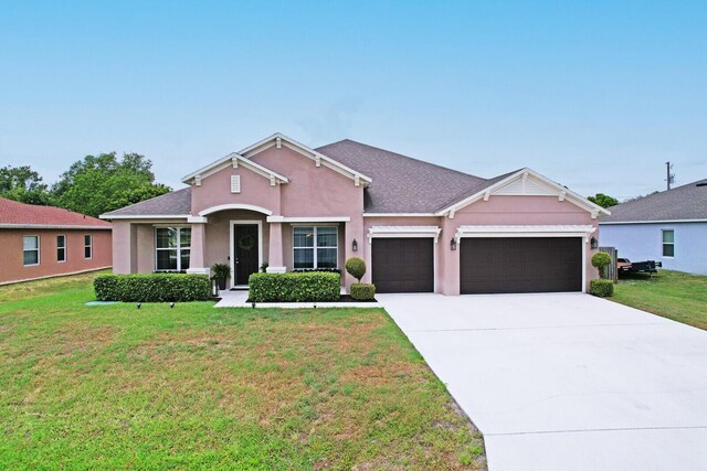 4052 SW Mccandless St, Port Saint Lucie, FL 34953 - view of front of property with a garage, a front yard, concrete driveway, and stucco siding