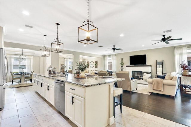 4052 SW Mccandless St, Port Saint Lucie, FL 34953 - kitchen with stainless steel appliances, a sink, a ceiling fan, plenty of natural light, and ornamental molding