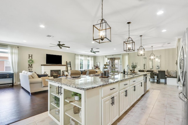 4052 SW Mccandless St, Port Saint Lucie, FL 34953 - kitchen with a sink, appliances with stainless steel finishes, ceiling fan, a center island with sink, and light stone countertops