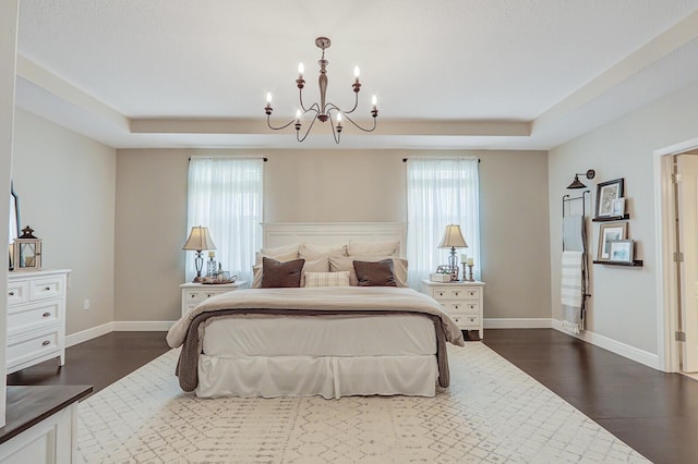 4052 SW Mccandless St, Port Saint Lucie, FL 34953 - bedroom featuring dark wood finished floors, a raised ceiling, a chandelier, and baseboards