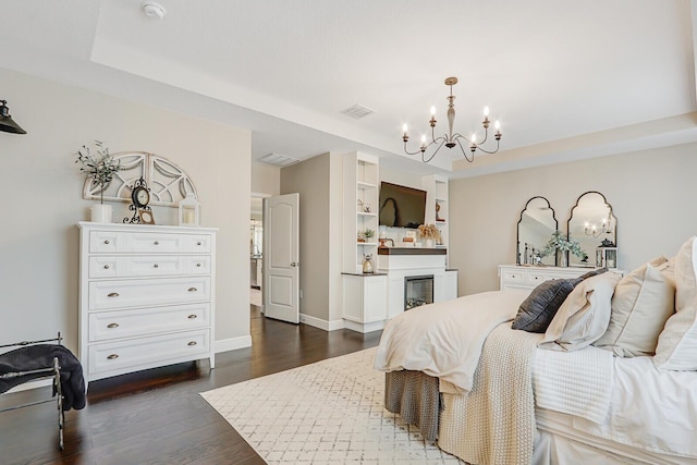 4052 SW Mccandless St, Port Saint Lucie, FL 34953 - bedroom with a chandelier, dark wood finished floors, a raised ceiling, baseboards, and a glass covered fireplace