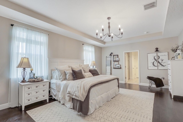 4052 SW Mccandless St, Port Saint Lucie, FL 34953 - bedroom with a raised ceiling, a chandelier, dark wood-style flooring, and baseboards