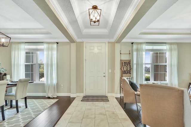 4052 SW Mccandless St, Port Saint Lucie, FL 34953 - entrance foyer featuring a chandelier, a raised ceiling, crown molding, wood finished floors, and baseboards