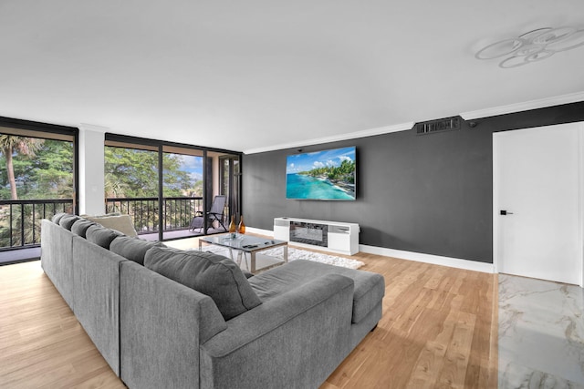 2480 Presidential Way Unit 303, West Palm Beach, FL 33401 - living area with crown molding, light wood-style flooring, heating unit, expansive windows, and baseboards