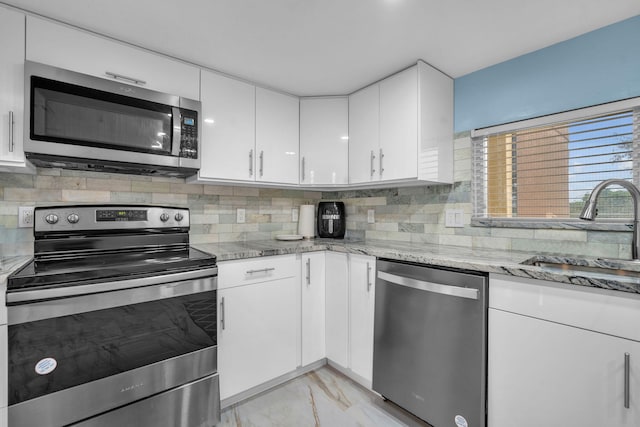 2480 Presidential Way Unit 303, West Palm Beach, FL 33401 - kitchen featuring appliances with stainless steel finishes, a sink, light marble finish floors, white cabinets, and light stone countertops