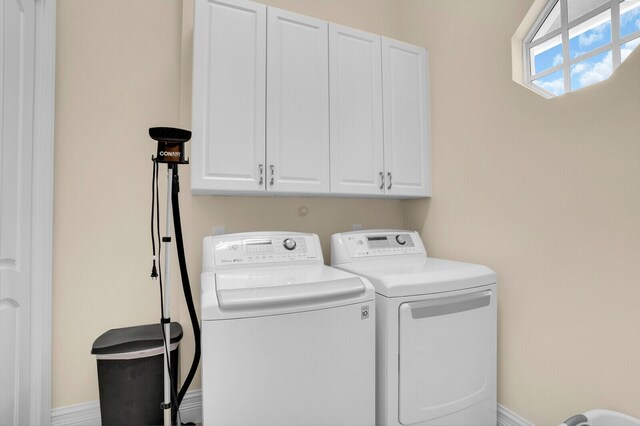 8380 Woodsmuir Dr, West Palm Beach, FL 33412 - laundry area with washing machine and clothes dryer, cabinet space, and baseboards
