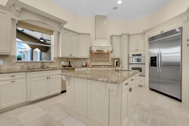 8380 Woodsmuir Dr, West Palm Beach, FL 33412 - kitchen with appliances with stainless steel finishes, a sink, ornamental molding, a kitchen island with sink, and light stone counters
