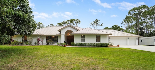ranch-style home with stucco siding, a standing seam roof, an attached garage, and metal roof