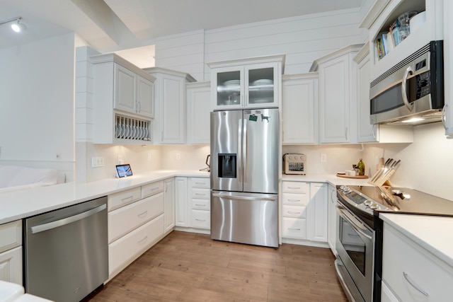 kitchen featuring stainless steel appliances, light wood-style flooring, light countertops, and white cabinets