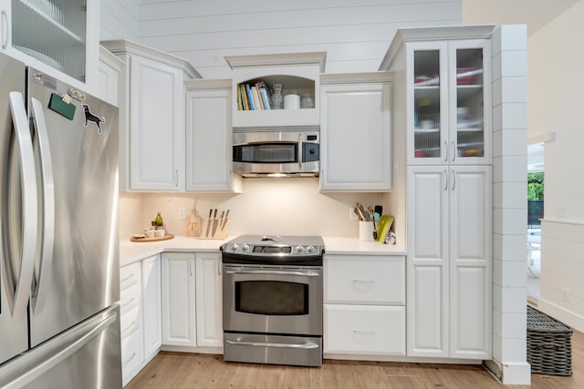 kitchen featuring stainless steel appliances, light countertops, and white cabinets