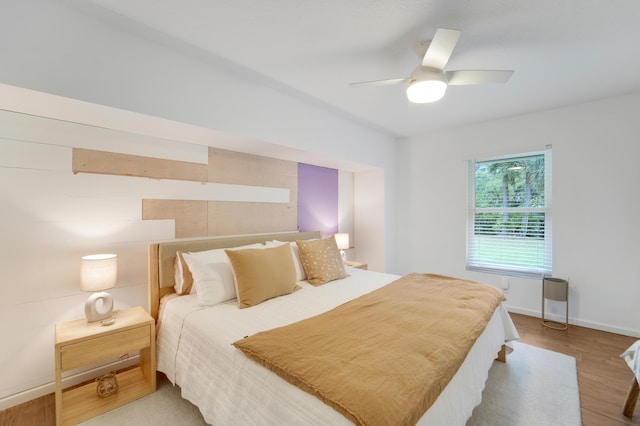 bedroom with wood finished floors, ceiling fan, and baseboards