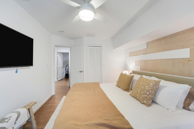 bedroom featuring wood finished floors, a closet, a ceiling fan, and baseboards