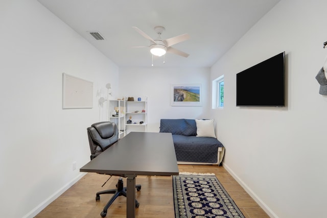 office space featuring a ceiling fan, light wood-type flooring, and baseboards