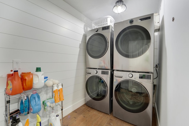 laundry room with stacked washer / dryer and light wood finished floors