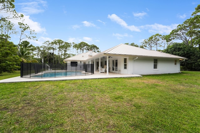 back of property with a ceiling fan, a patio area, metal roof, a chimney, and a standing seam roof