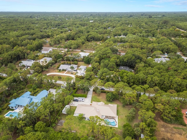 aerial view of property's location featuring a forest and a pool area