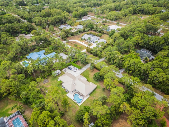 aerial view of residential area featuring a pool and a heavily wooded area