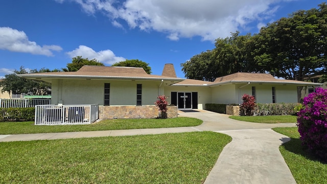 view of front of property with stucco siding, concrete driveway, a chimney, and stone siding