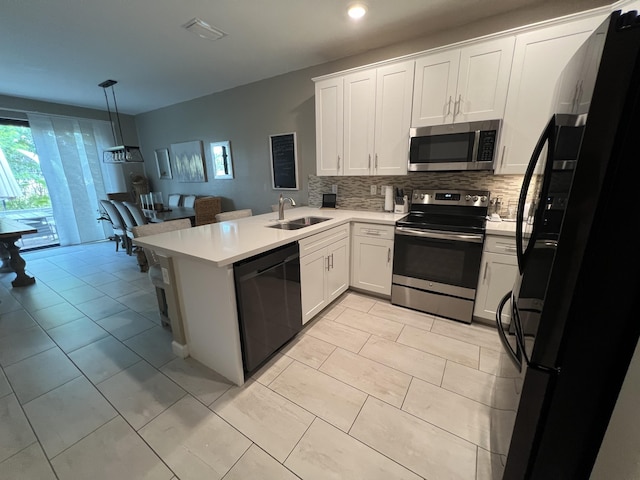 13044 Anthorne Ln, Boynton Beach, FL 33436 - kitchen with black appliances, a sink, decorative backsplash, light countertops, and a peninsula