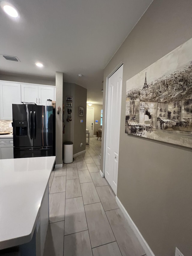 13044 Anthorne Ln, Boynton Beach, FL 33436 - kitchen featuring black fridge, white cabinetry, light countertops, and recessed lighting