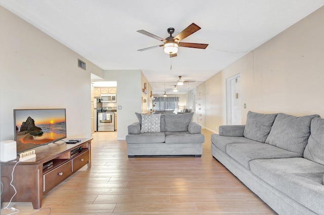 living area with a ceiling fan and light wood-style floors