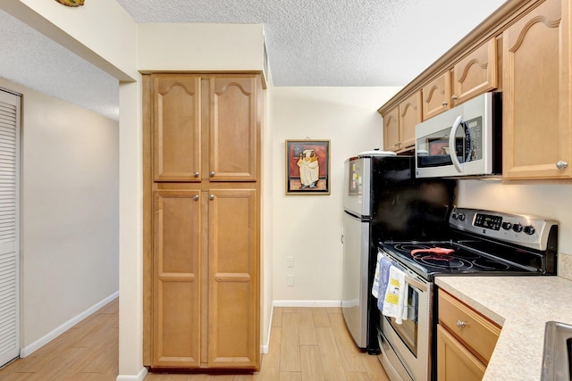 kitchen featuring electric stove, a textured ceiling, light countertops, light wood-type flooring, and baseboards