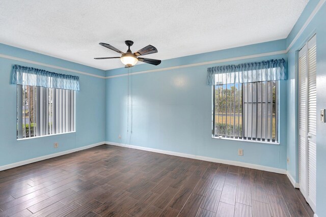 empty room featuring ceiling fan, plenty of natural light, baseboards, wood finished floors, and a textured ceiling