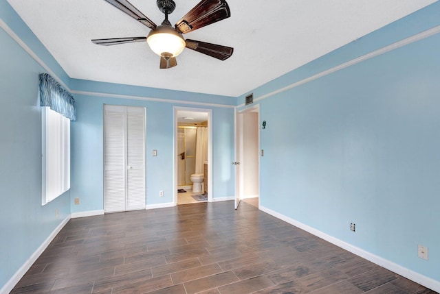 unfurnished bedroom featuring baseboards, dark wood-type flooring, a closet, and a ceiling fan